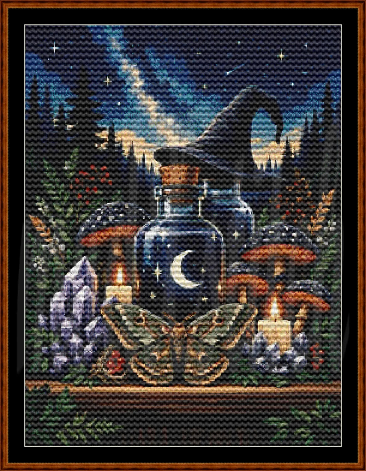 A framed witch-themed needlepoint or cross-stitch design featuring a dark blue night sky with stars and a shooting star, two glass bottles with moon symbols, a witch hat, mushrooms, candles, crystals, and a large moth on a wooden surface.