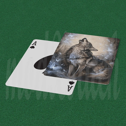 A custom playing card featuring an artistic illustration of a howling wolf amidst smoke, shown partially slid off a standard white Ace of Spades card on a green felt surface.